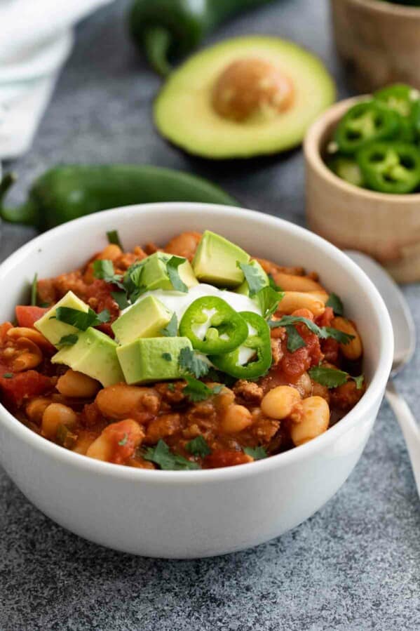 bowl of ground turkey chili with toppings