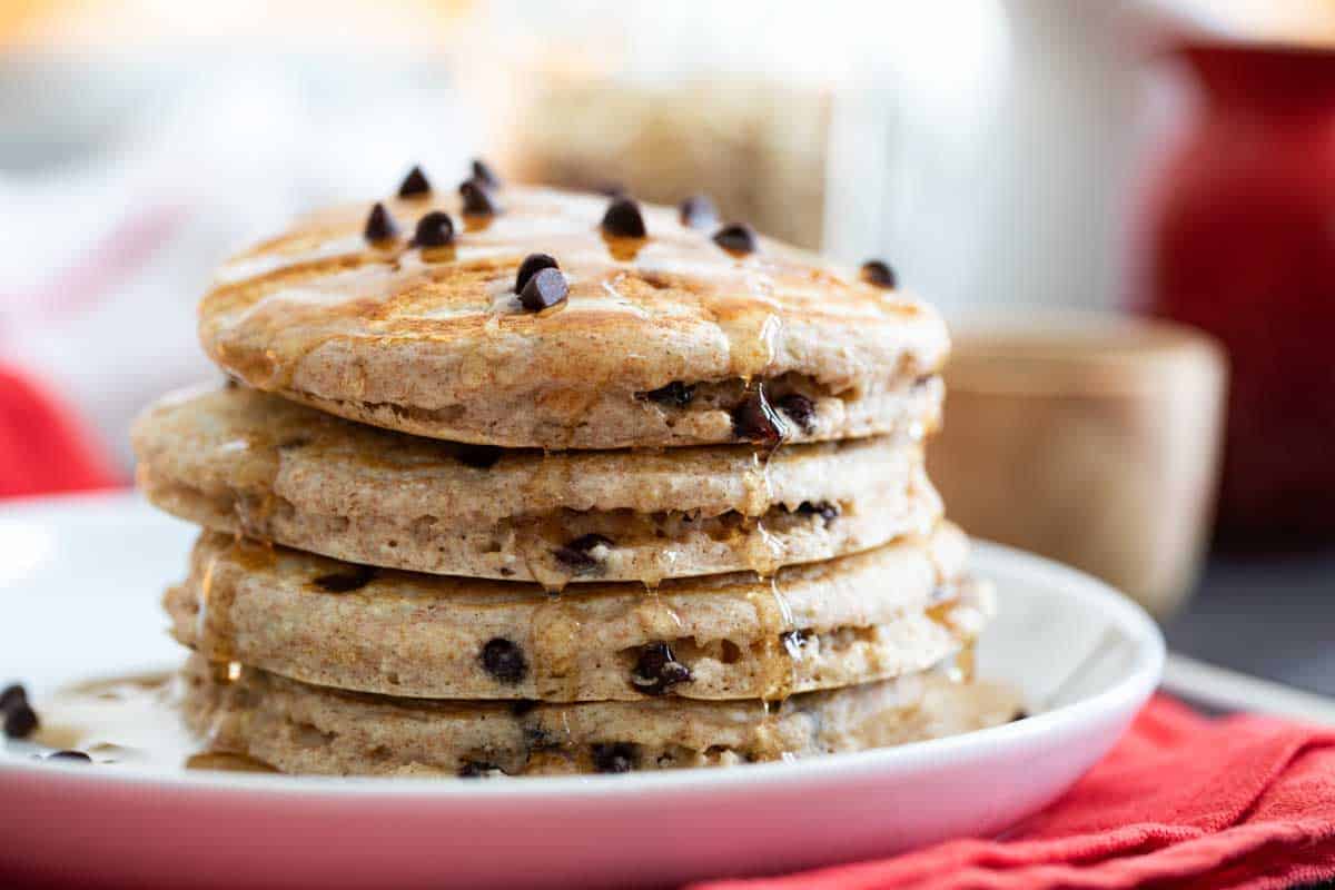 stack of oatmeal pancakes with chocolate chips drizzled with syrup