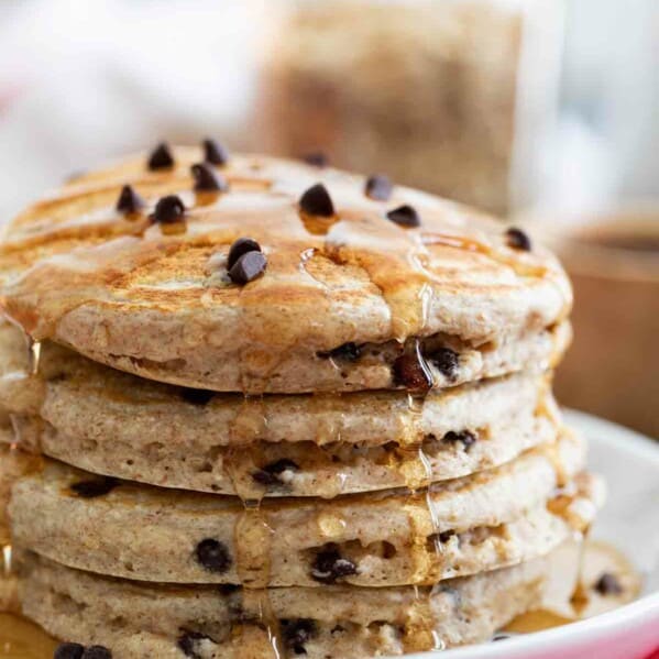 stack of whole wheat oatmeal pancakes drizzled with syrup