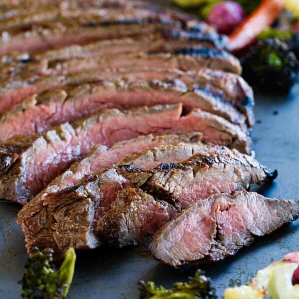 full sliced flank steak on a baking sheet