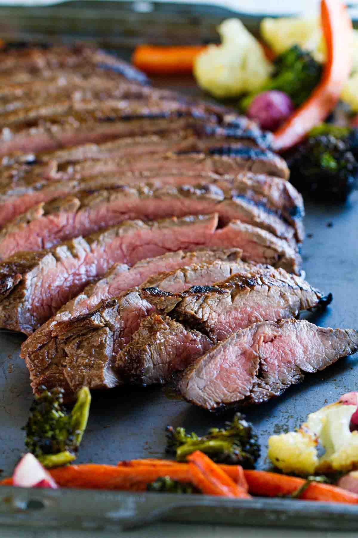 full sliced flank steak on a baking sheet