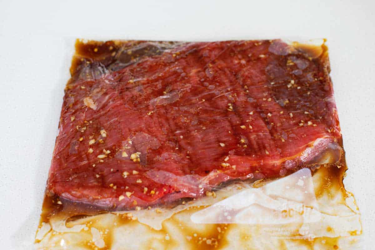 flank steak with marinade in a bag