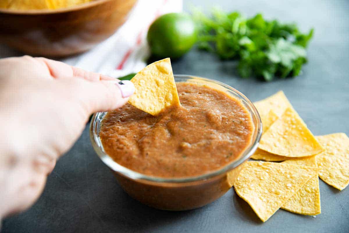 dipping a chip into homemade salsa