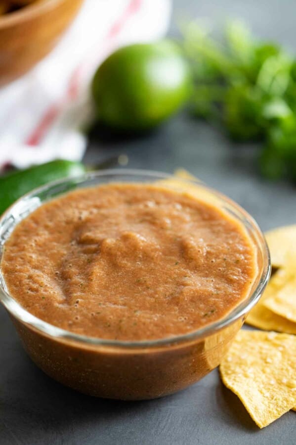 Homemade Salsa in a bowl with ingredients in the background