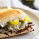 Slow Cooker Italian Beef Sandwich with cheese and peppers on a plate