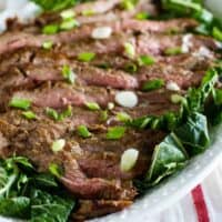 Korean Barbecue Flank Steak on a plate with greens
