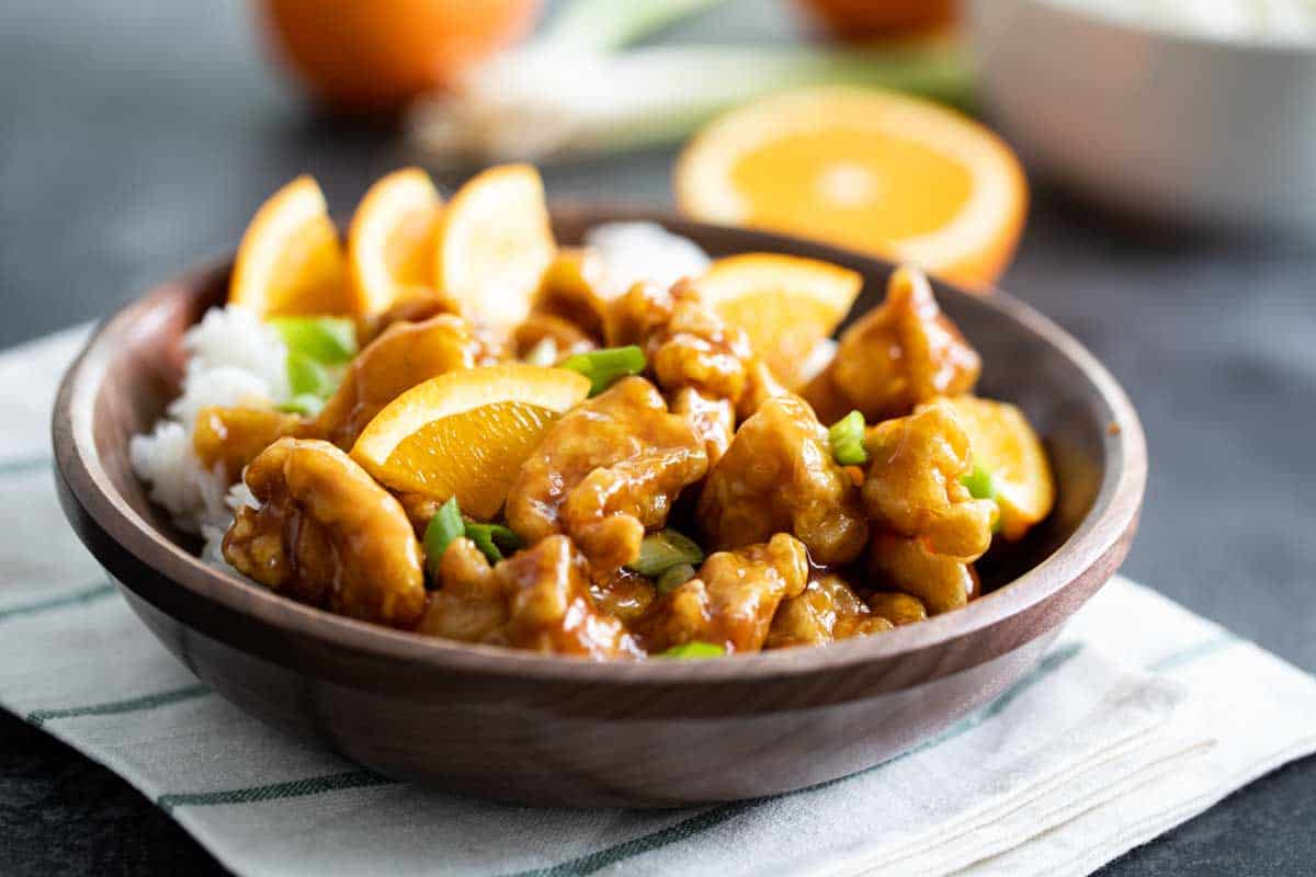 Better than take-out, this Orange Chicken Recipe is easy to make at home. It is full of flavor and will have you wanting more! bowl with rice and orange chicken