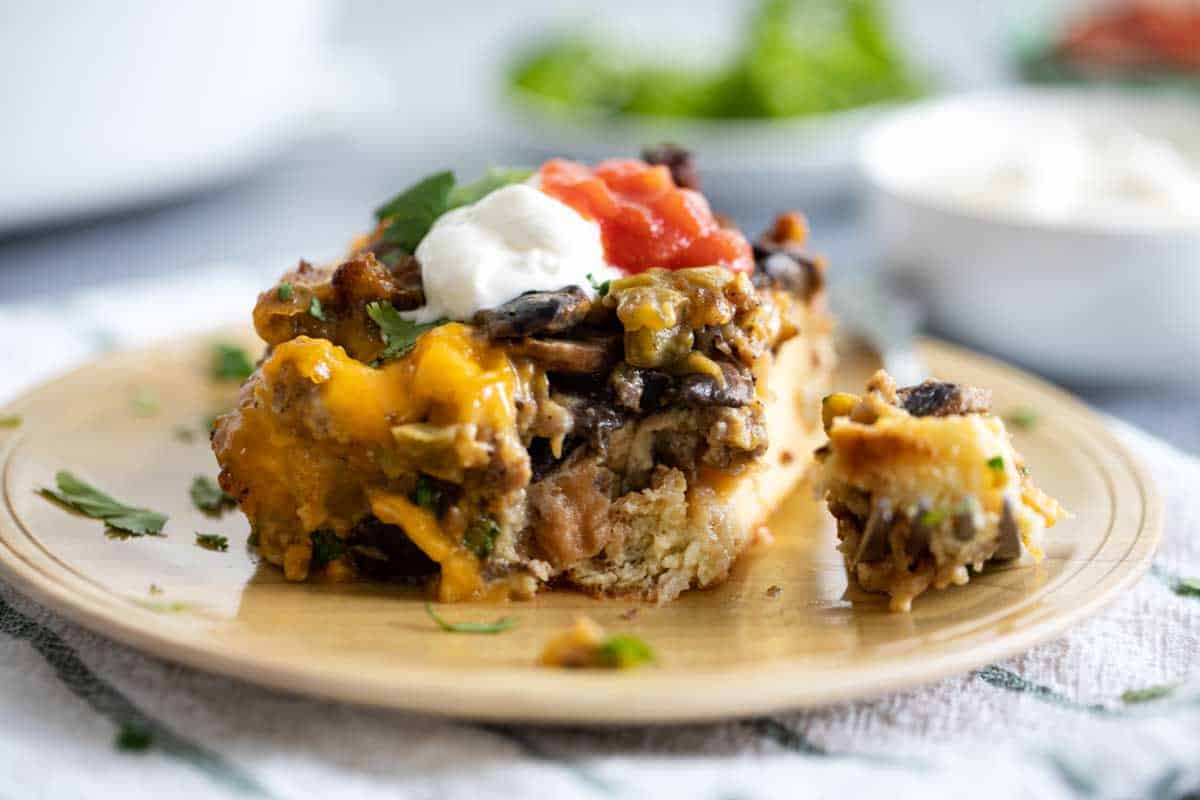 Filled with sausage, mushrooms and green chiles, this Sausage Breakfast Casserole is hearty and filling. Plus, all of the work is done the night before, which makes breakfast a snap! slice of sausage breakfast casserole with a forkful taken