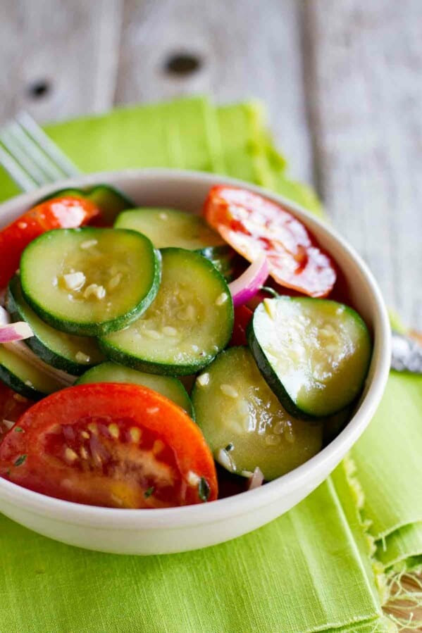 bowl of zucchini salad with tomatoes and red onions