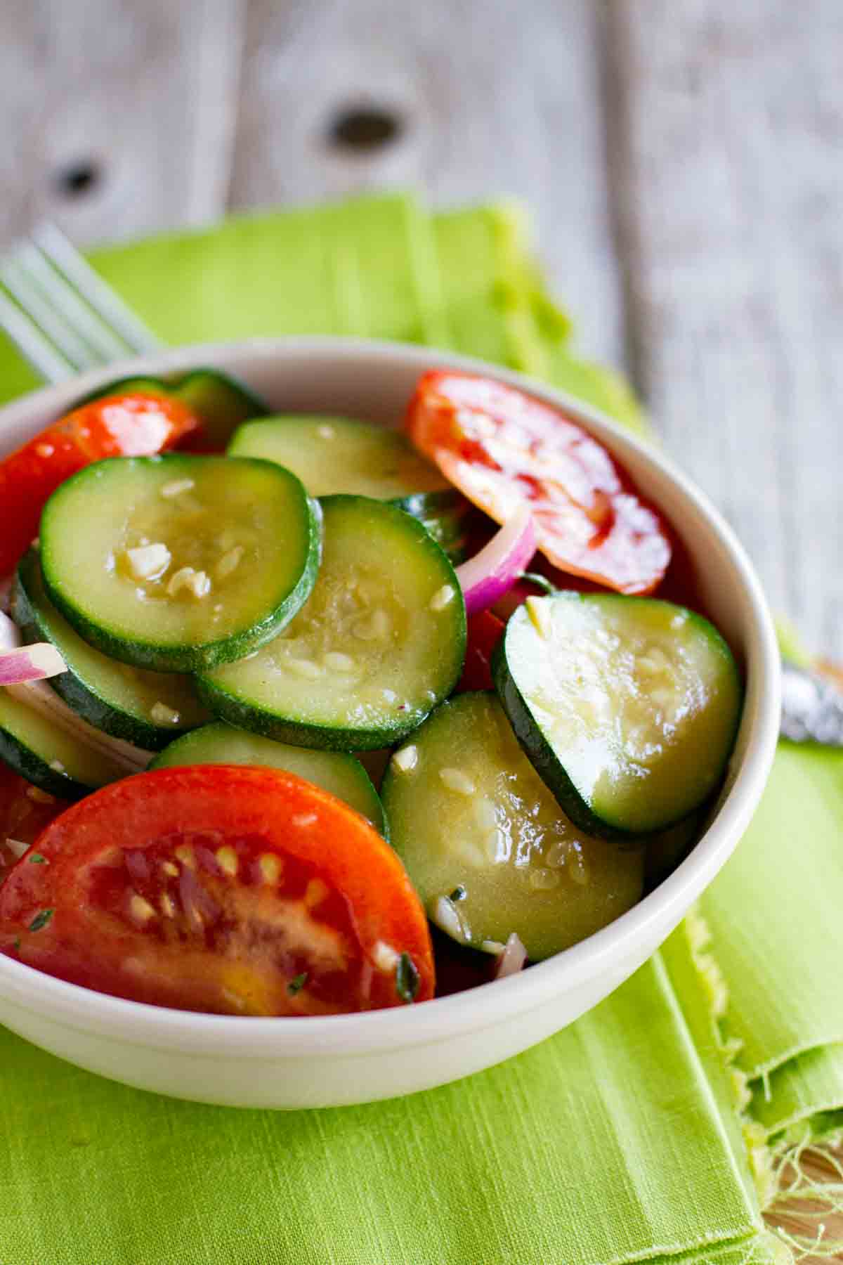 bowl of zucchini salad with tomatoes and red onions