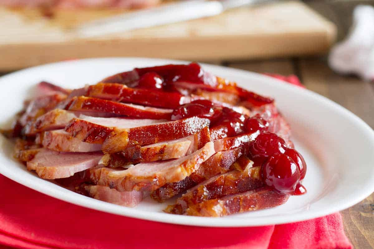 serving plate with ham glazed with cherries