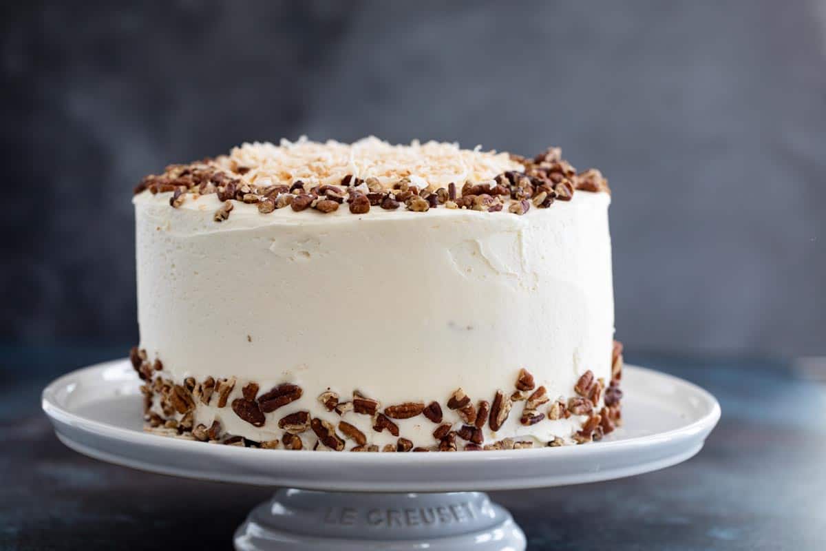 whole carrot cake decorated with pecans and coconut