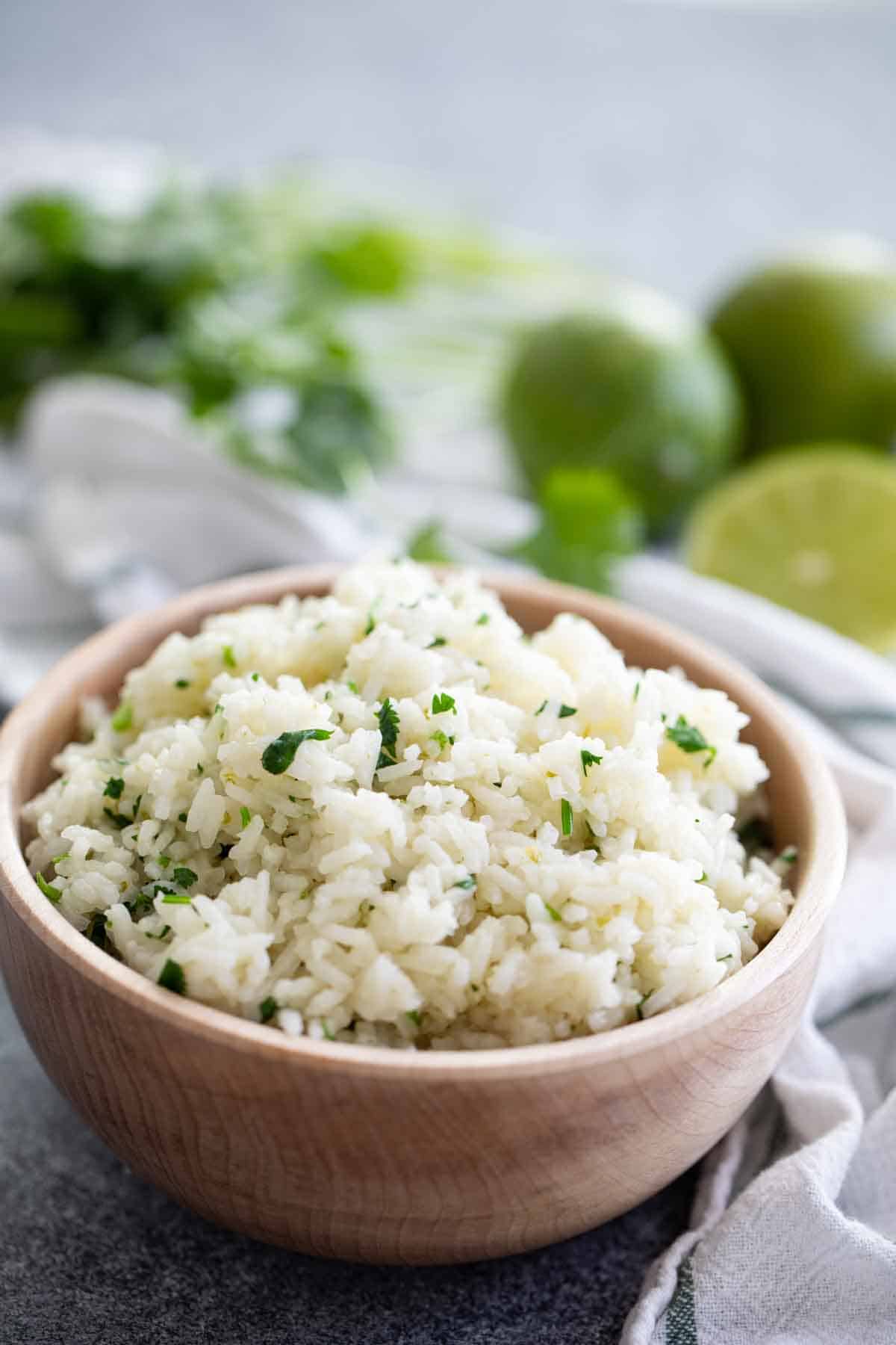 bowl of cilantro lime rice with limes in the background