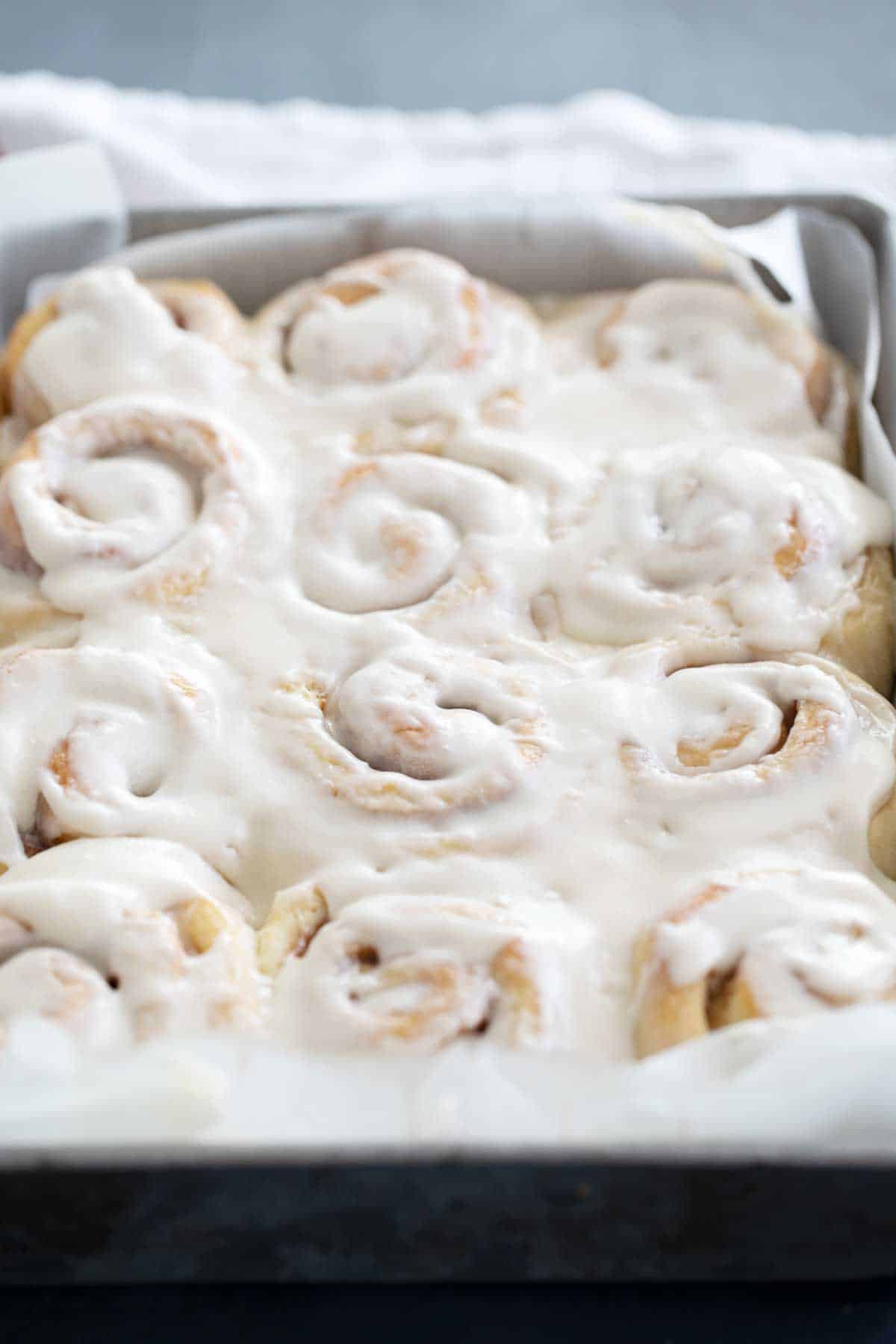 pan full of cinnamon rolls with icing
