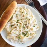 overhead view of Easy Alfredo Sauce and pasta on a plate with a breadstick