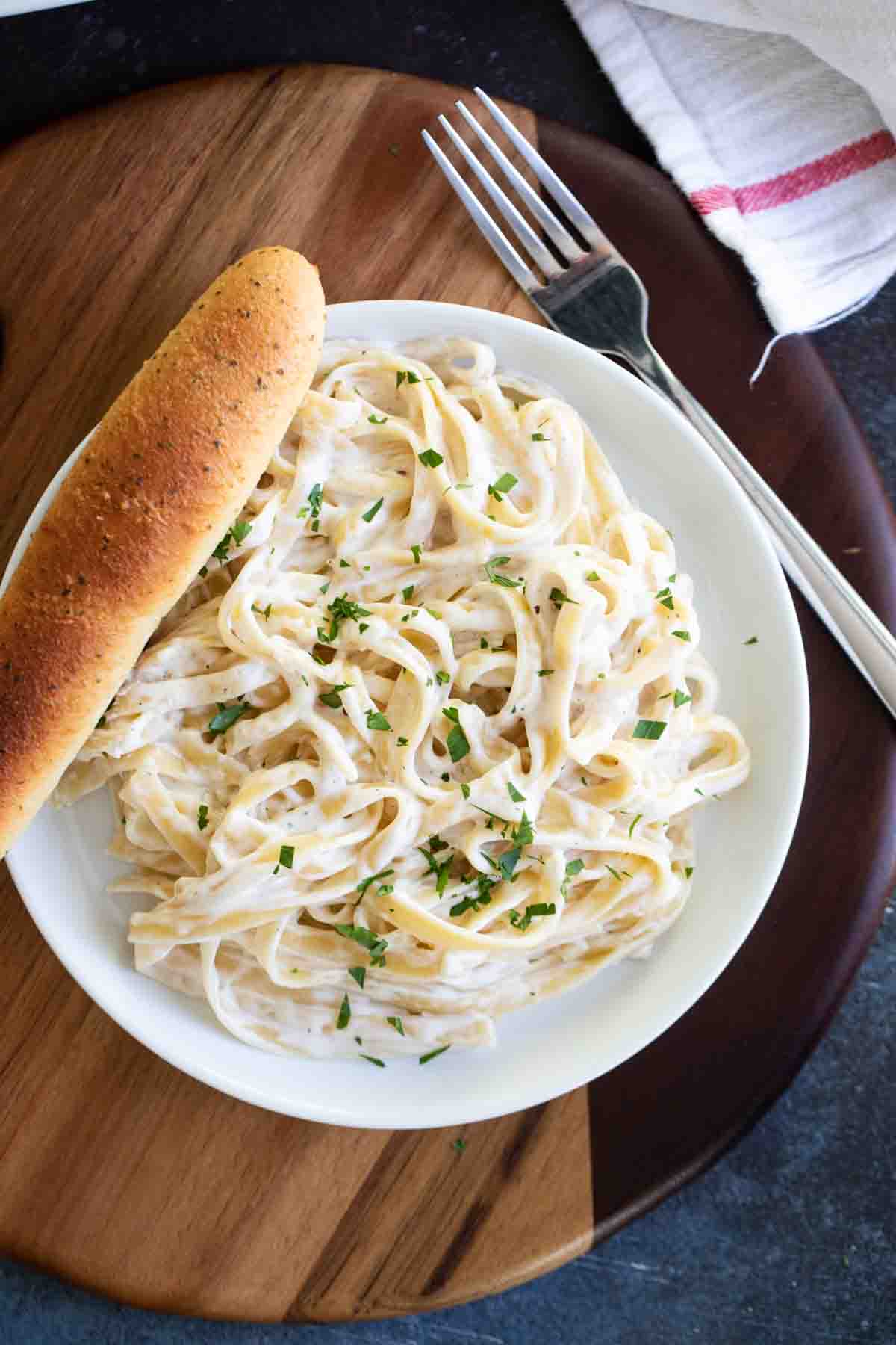 overhead view of Easy Alfredo Sauce and pasta on a plate with a breadstick