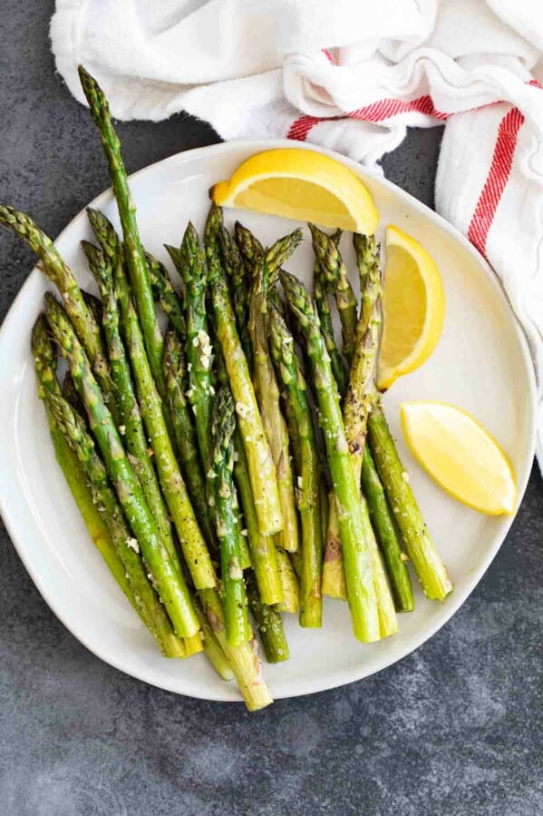 overhead view of roasted asparagus on a white plate