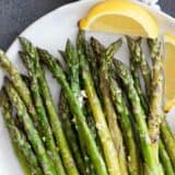 roasted asparagus on a plate with lemon slices