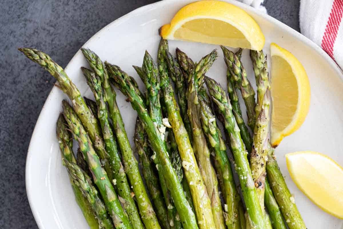 roasted asparagus on a plate with lemon slices