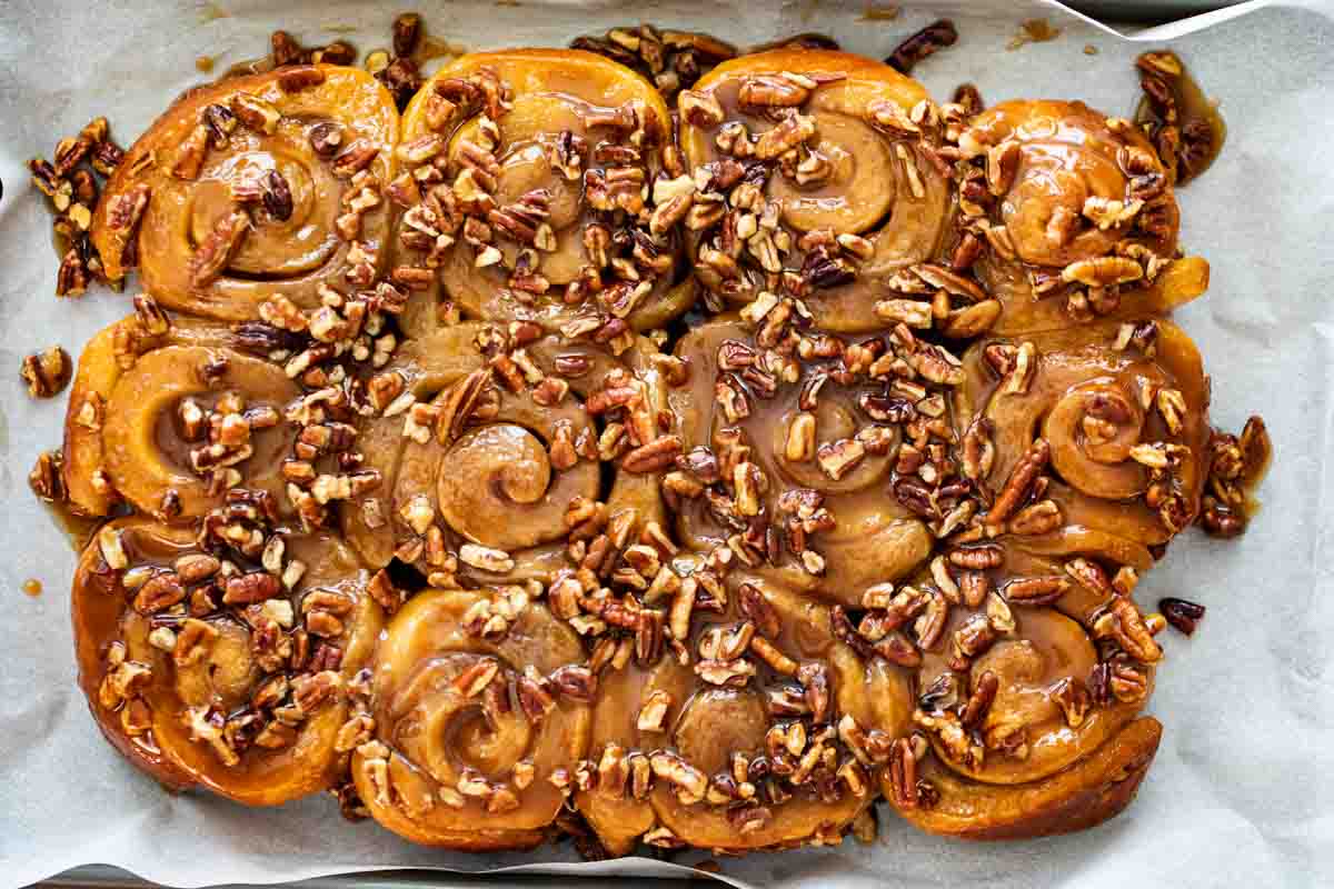 sticky buns that have been turned out from the pan onto a piece of parchment paper