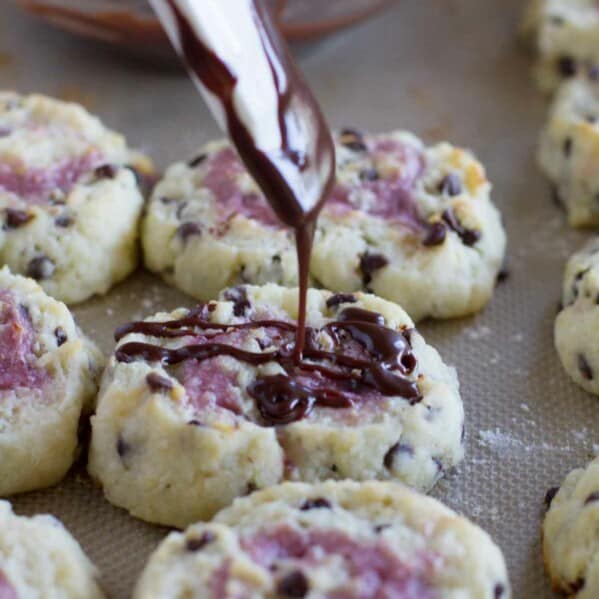 drizzling chocolate over a chocolate chip biscuit