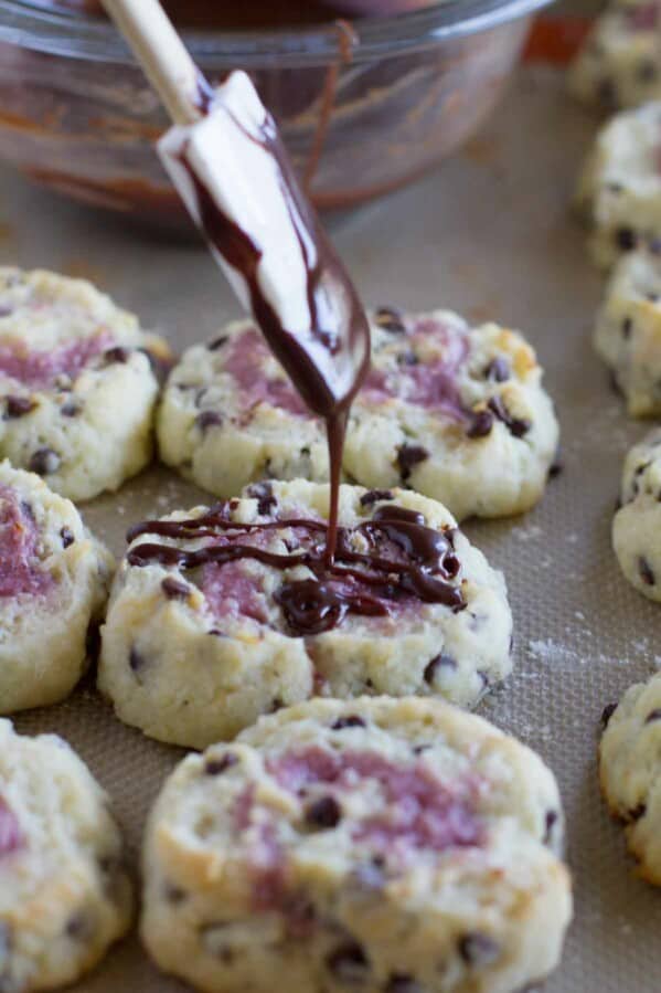 drizzling chocolate over a chocolate chip biscuit