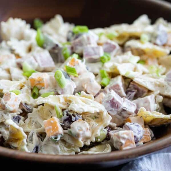 wooden bowl filled with bow tie pasta salad with creamy dressing