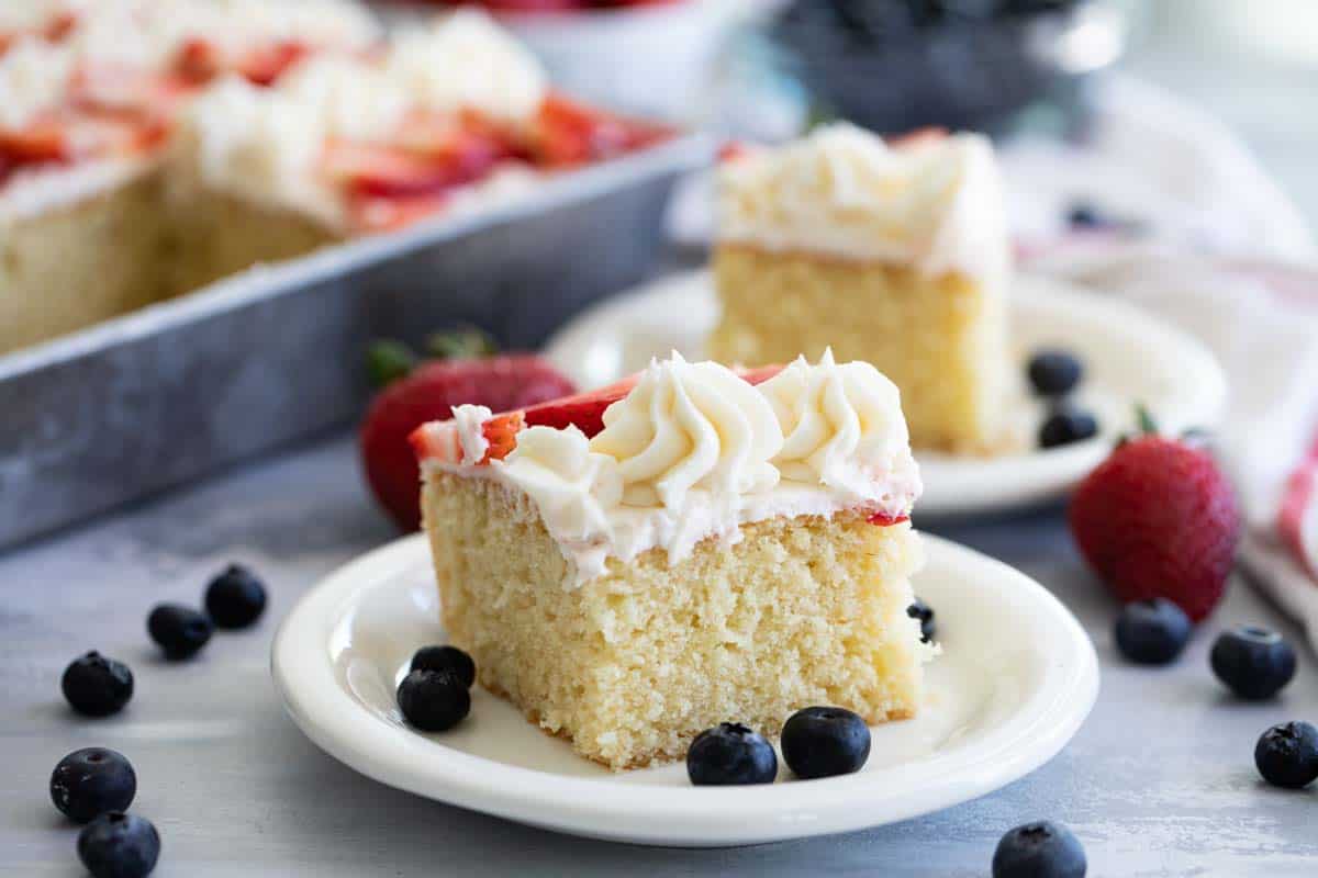 slice of flag cake on a white plate with fruit