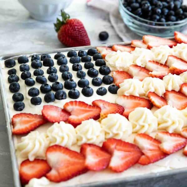 American flag cake topped with buttercream, strawberries and blueberries