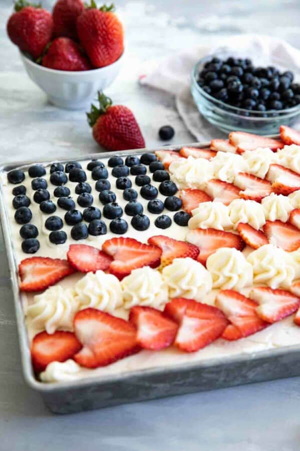 American flag cake topped with buttercream, strawberries and blueberries