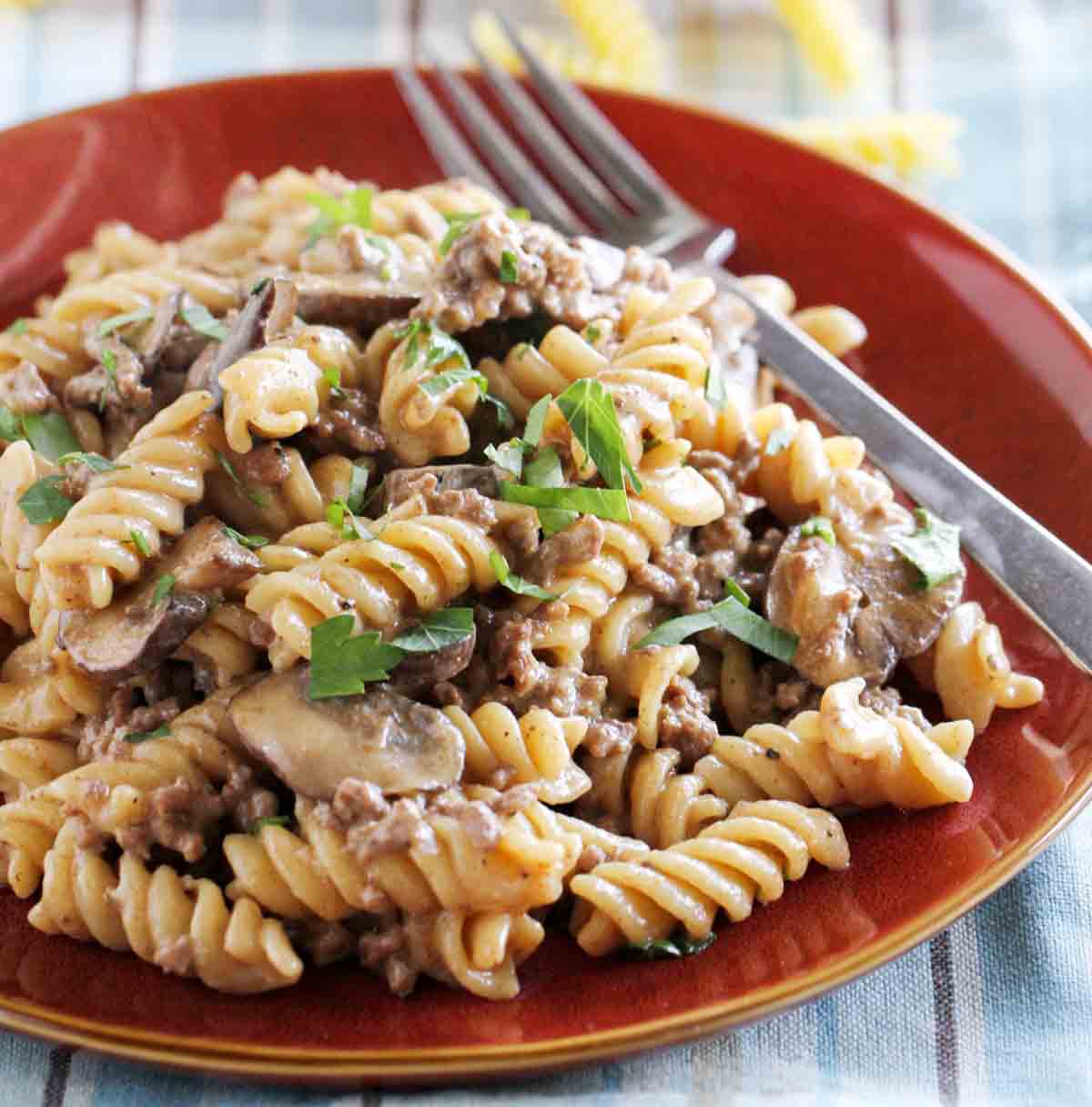 plate with one pot ground beef stroganoff garnished with parsley