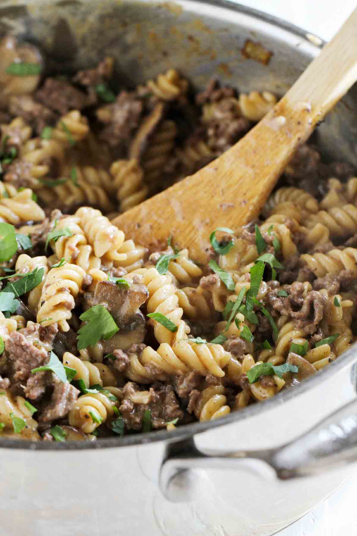 pot with ground beef stroganoff and wooden spoon