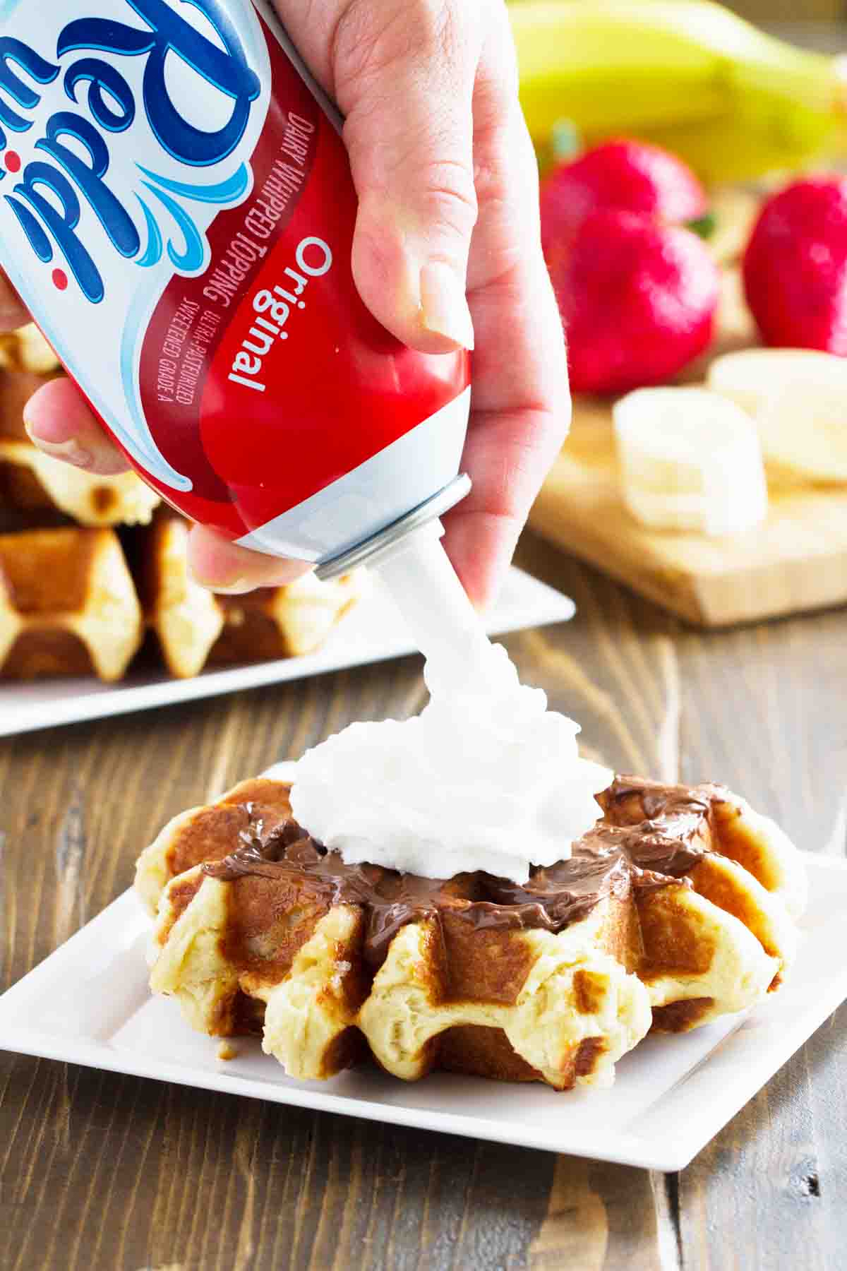 putting whipped topping on a liege waffle