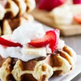 Liege waffle topped with nutella, bananas, strawberries and whipped cream