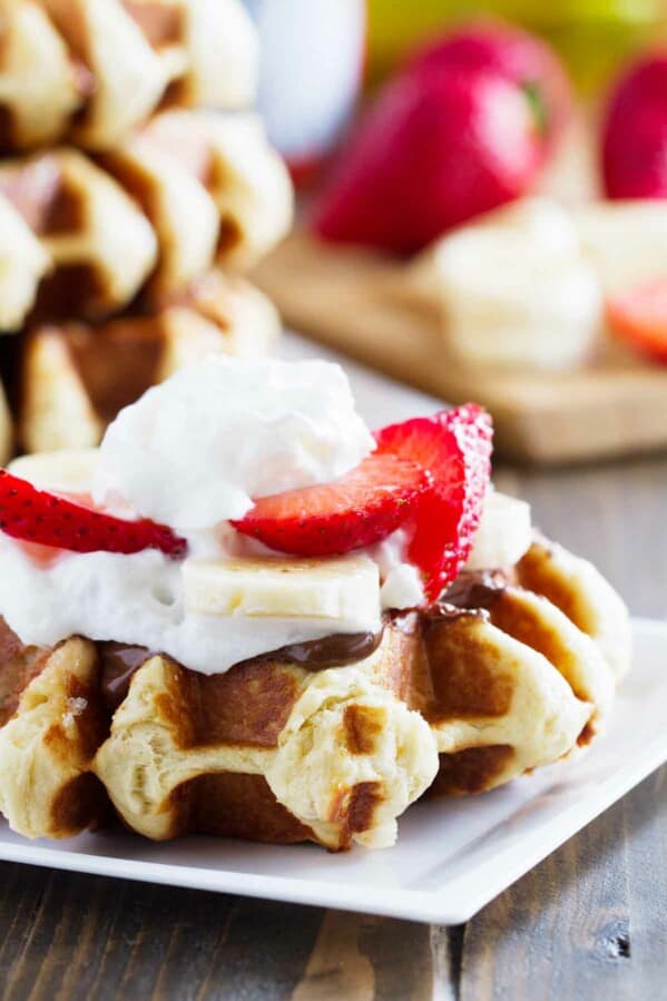 Liege waffle topped with nutella, bananas, strawberries and whipped cream