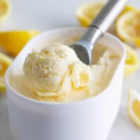container of lemon ice cream with a scoop in the middle