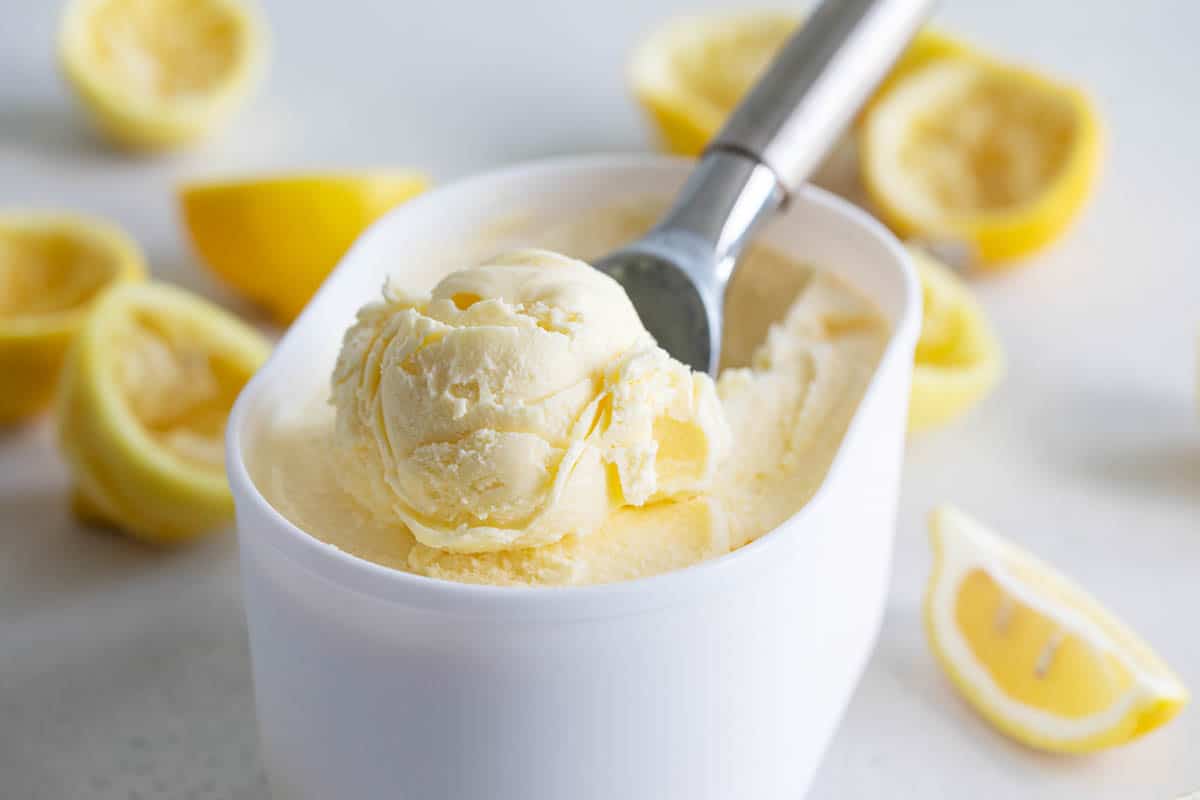 container of lemon ice cream with a scoop in the middle