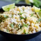 bowl of Mexican Corn Salad with limes and cilantro