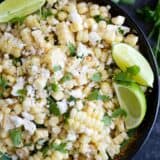 overhead view of grilled corn salad with cheese, cilantro and limes