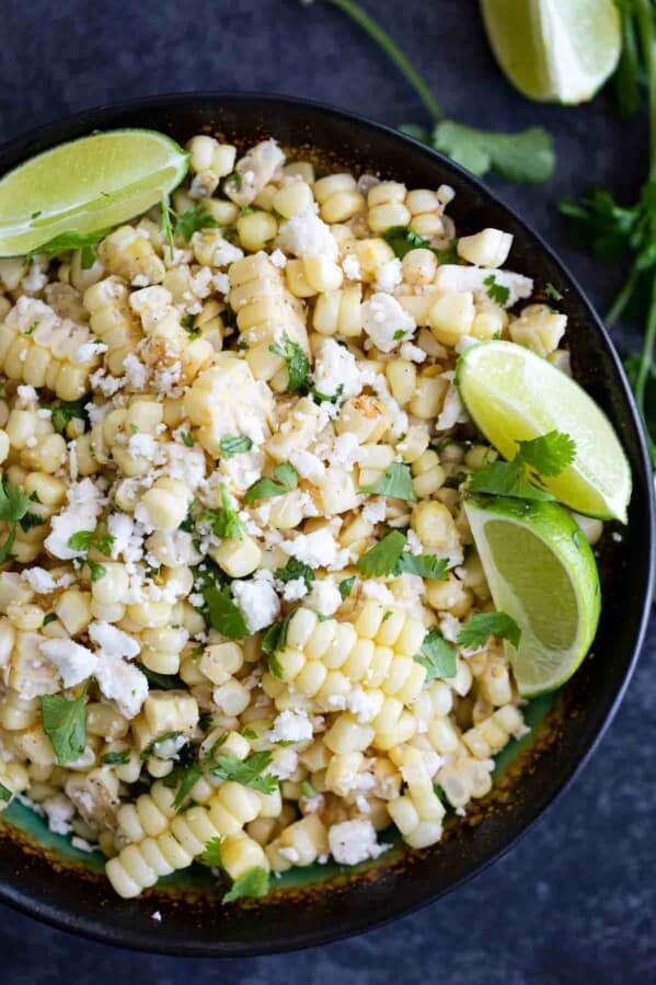 overhead view of grilled corn salad with cheese, cilantro and limes