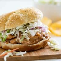 Teriyaki Chicken Sandwich topped with coleslaw on a cutting board