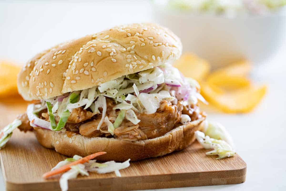 Teriyaki Chicken Sandwich topped with coleslaw on a cutting board