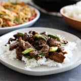 Mongolian Beef over rice on a white plate