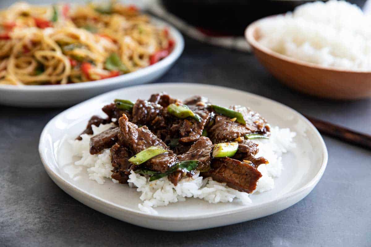 Mongolian Beef over rice on a white plate