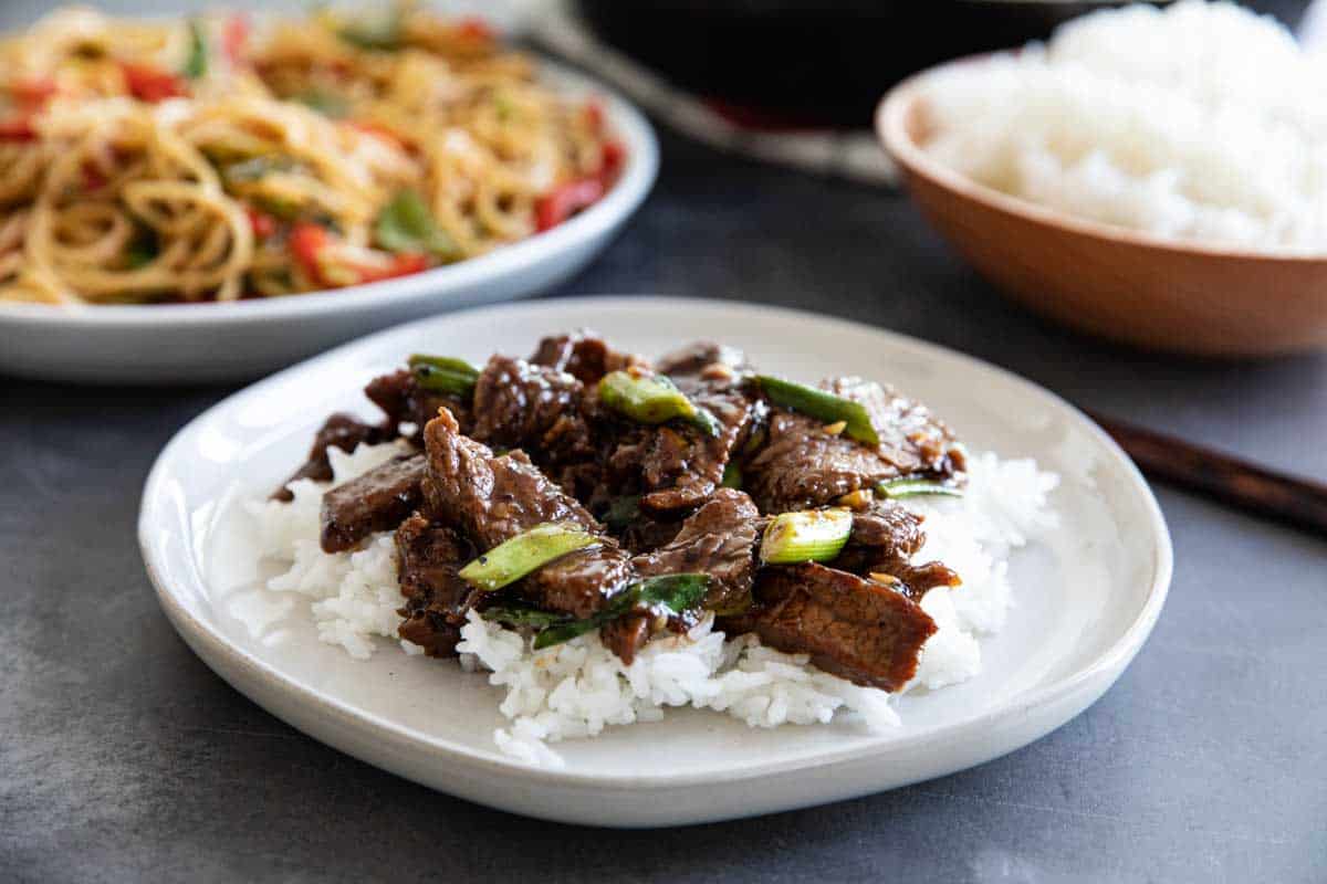 A simple beef dish full of Chinese flavors, this Mongolian Beef comes together quickly so you’ll have dinner on the table faster than order take-out! Mongolian Beef over rice on a white plate
