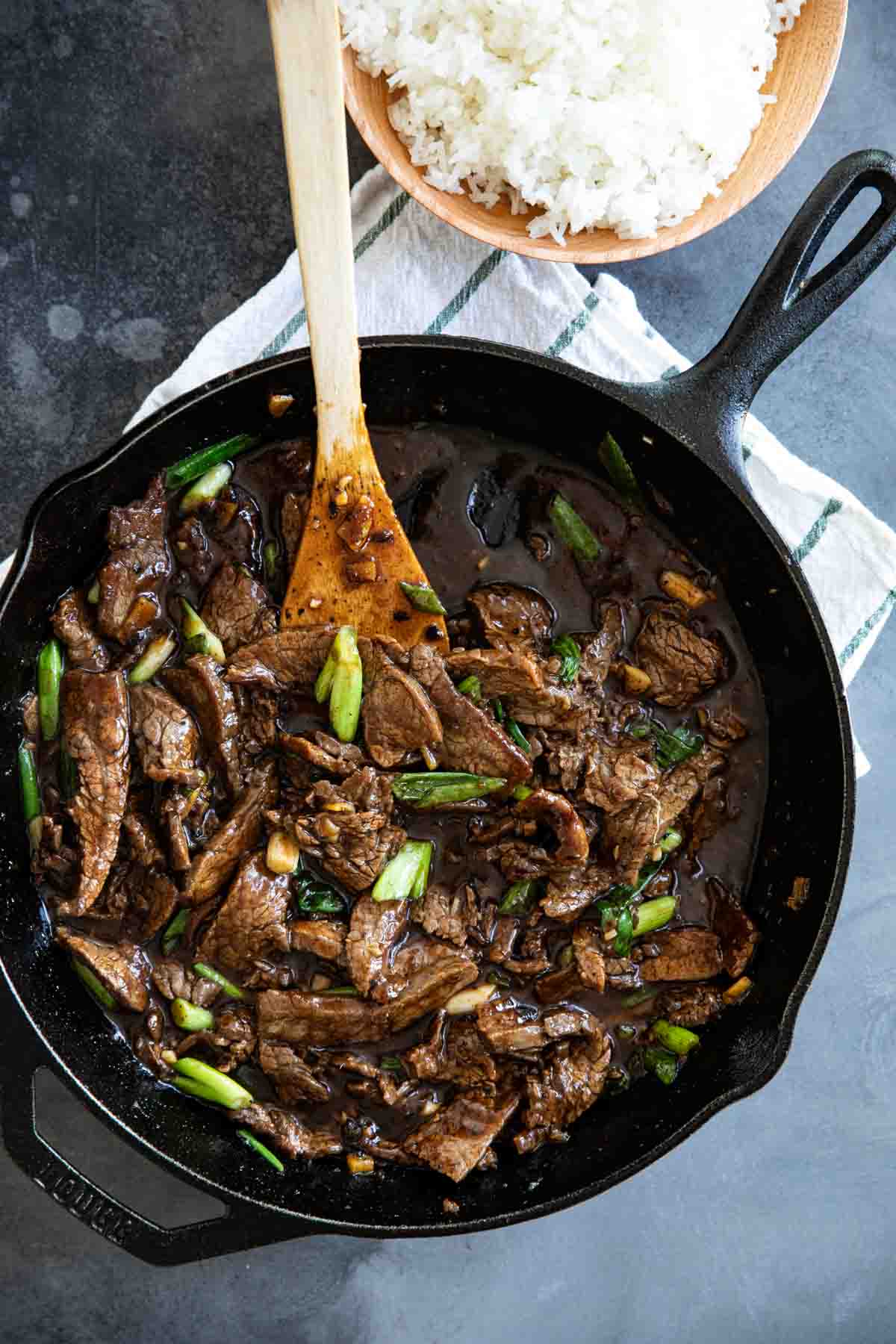 A simple beef dish full of Chinese flavors, this Mongolian Beef comes together quickly so you’ll have dinner on the table faster than order take-out! mongolian beef in a cast iron skillet