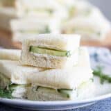 cucumber sandwiches stacked on a plate