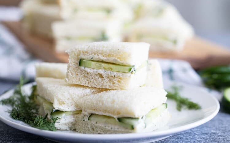 cucumber sandwiches stacked on a plate