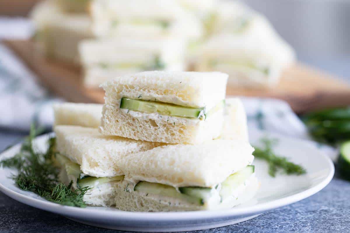 cucumber sandwiches stacked on a plate