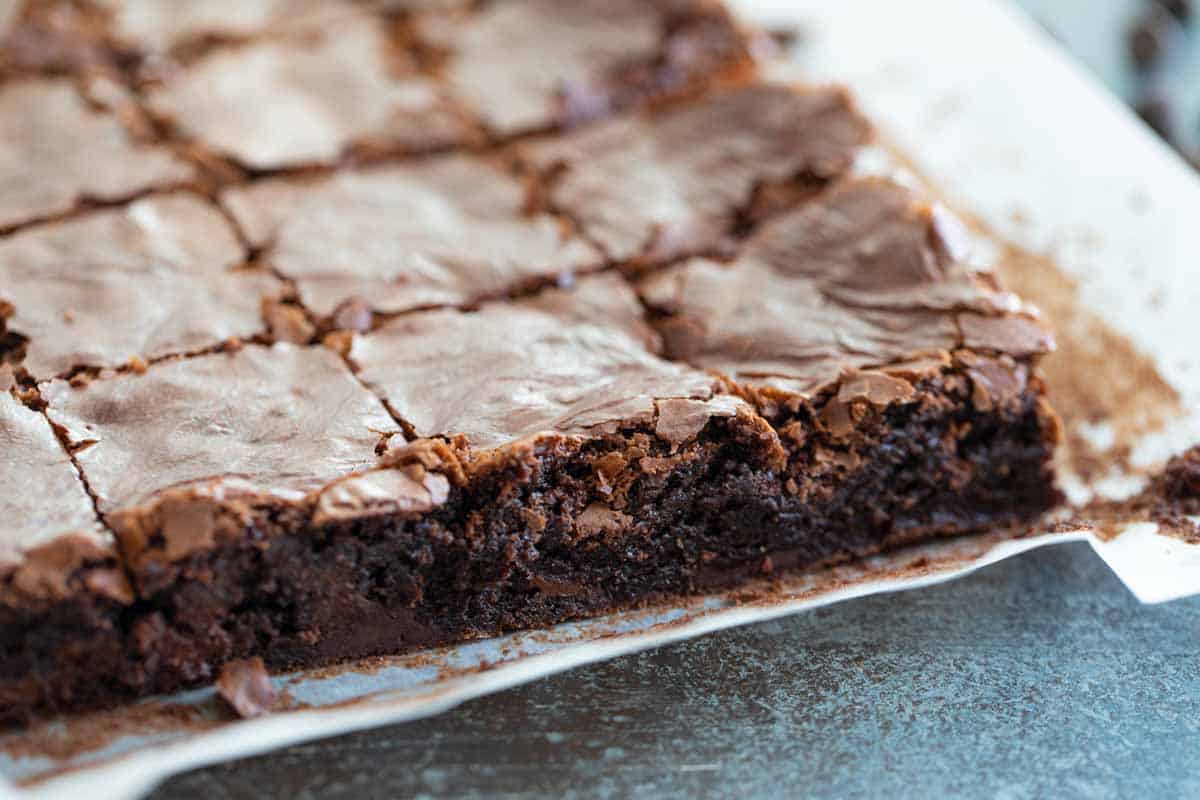 homemade brownies on parchment paper cut into squares